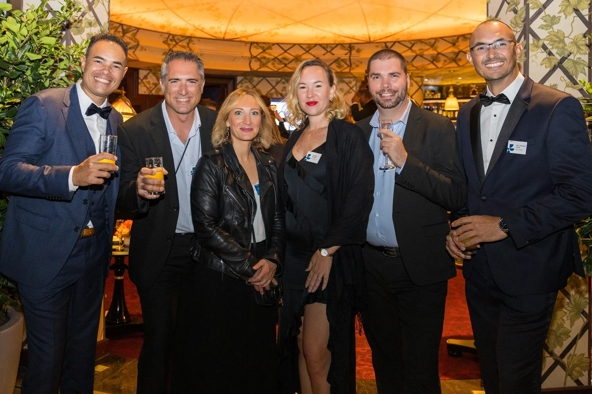 Groupe d'invités en tenue de soirée dans un lieu de prestige lors d'un événement d'entreprise