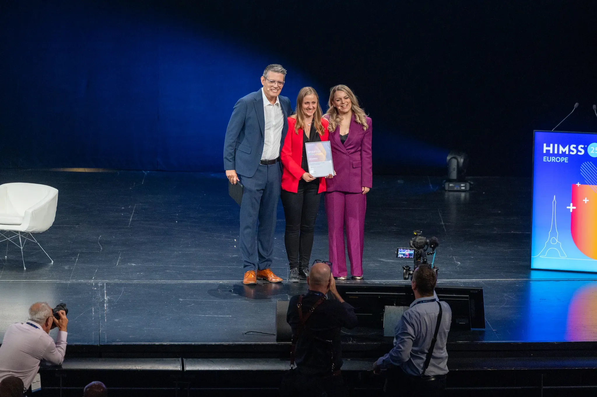Lauréats sur scène recevant leur trophée lors d'une soirée d'entreprise, groupe net sous les projecteurs